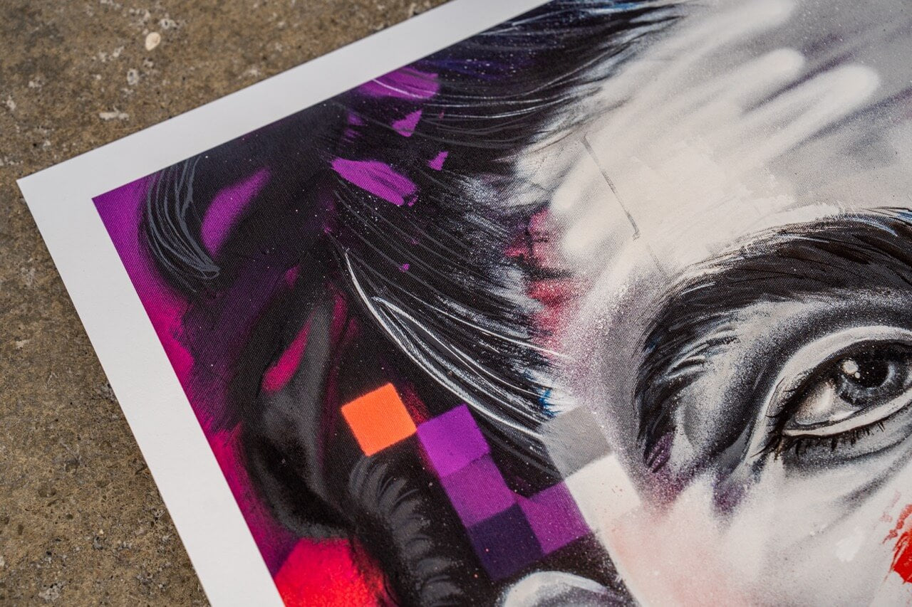 Detailaufnahme eines Graffiti-Art-Prints von Stone Graffiti. Das Bild zeigt einen Ausschnitt eines hyperrealistischen Porträts mit schwarz-weißen Schattierungen, ergänzt durch geometrische Farbakzente in Lila, Orange und Rot. Der künstlerische Stil kombiniert realistische Maltechniken mit abstrakten Elementen. Die spiegelnden Lichteffekte und dynamischen Pinselstriche erzeugen eine intensive visuelle Tiefe. Der Kunstdruck liegt auf einer rauen Betonoberfläche, die den urbanen Charakter der Street-Art verstä