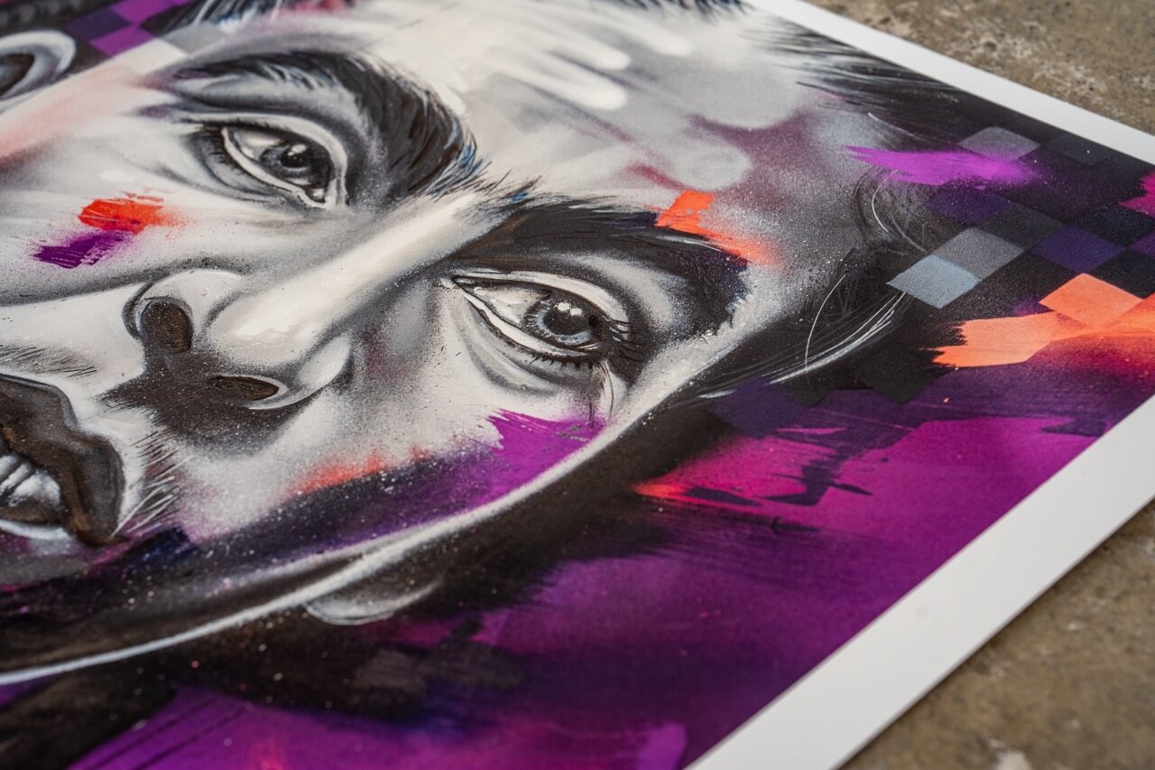 Nahaufnahme eines Graffiti-Art-Prints von Stone Graffiti. Das Kunstwerk zeigt ein hyperrealistisches Porträt mit ausdrucksstarken Augen, umgeben von kräftigen Farbakzenten in Lila, Orange und Schwarz. Die Kombination aus weichen Schattierungen, abstrakten Formen und gesprühten Details verleiht dem Bild eine dynamische, urbane Ästhetik. Der hochwertige Druck liegt auf einer Betonoberfläche, was den Street-Art-Charakter zusätzlich betont.