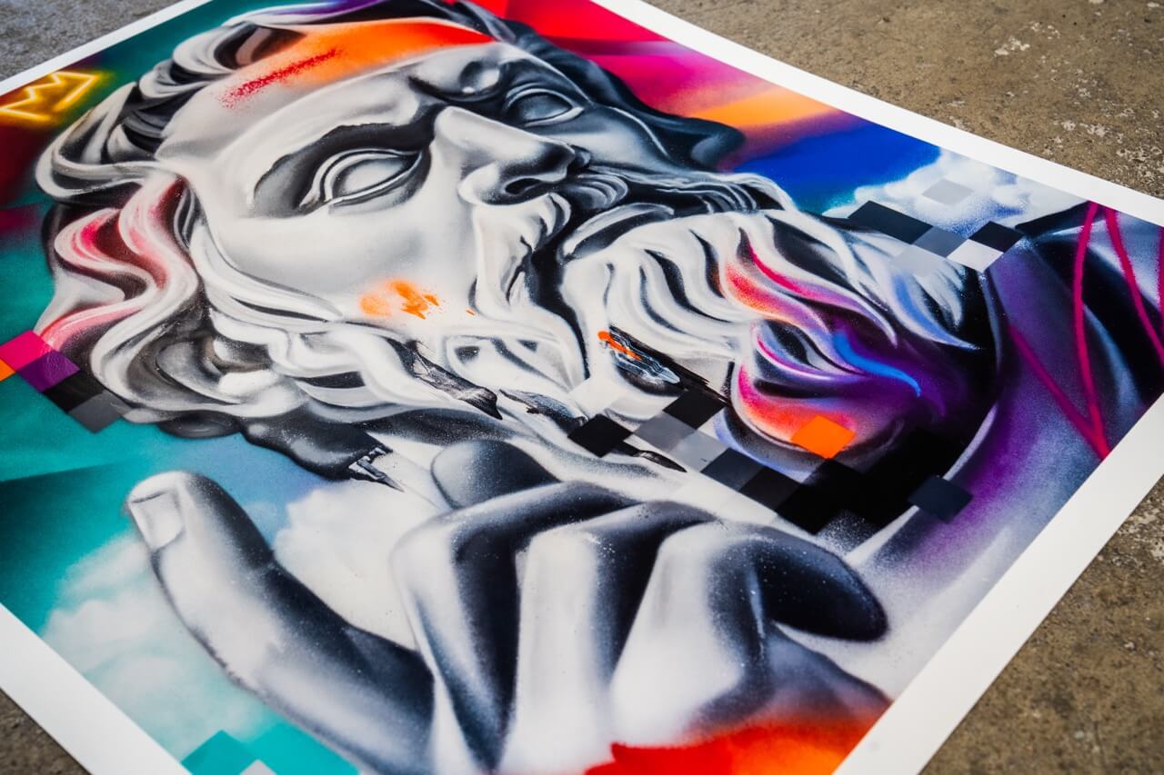 Detailaufnahme eines Kunstdrucks von Stone Graffiti, der eine klassisch anmutende Statue mit modernen, digitalen Elementen kombiniert. Die Statue ist in Schwarz-Weiß gehalten, mit dynamischen Farbakzenten in Orange, Blau, Pink und Lila. Die Oberfläche zeigt eine Mischung aus realistischen Schattierungen und abstrakten, verpixelten Mustern. In der oberen linken Ecke ist eine stilisierte, leuchtende Krone zu sehen. Der Kunstdruck liegt auf einem rauen Betonboden.