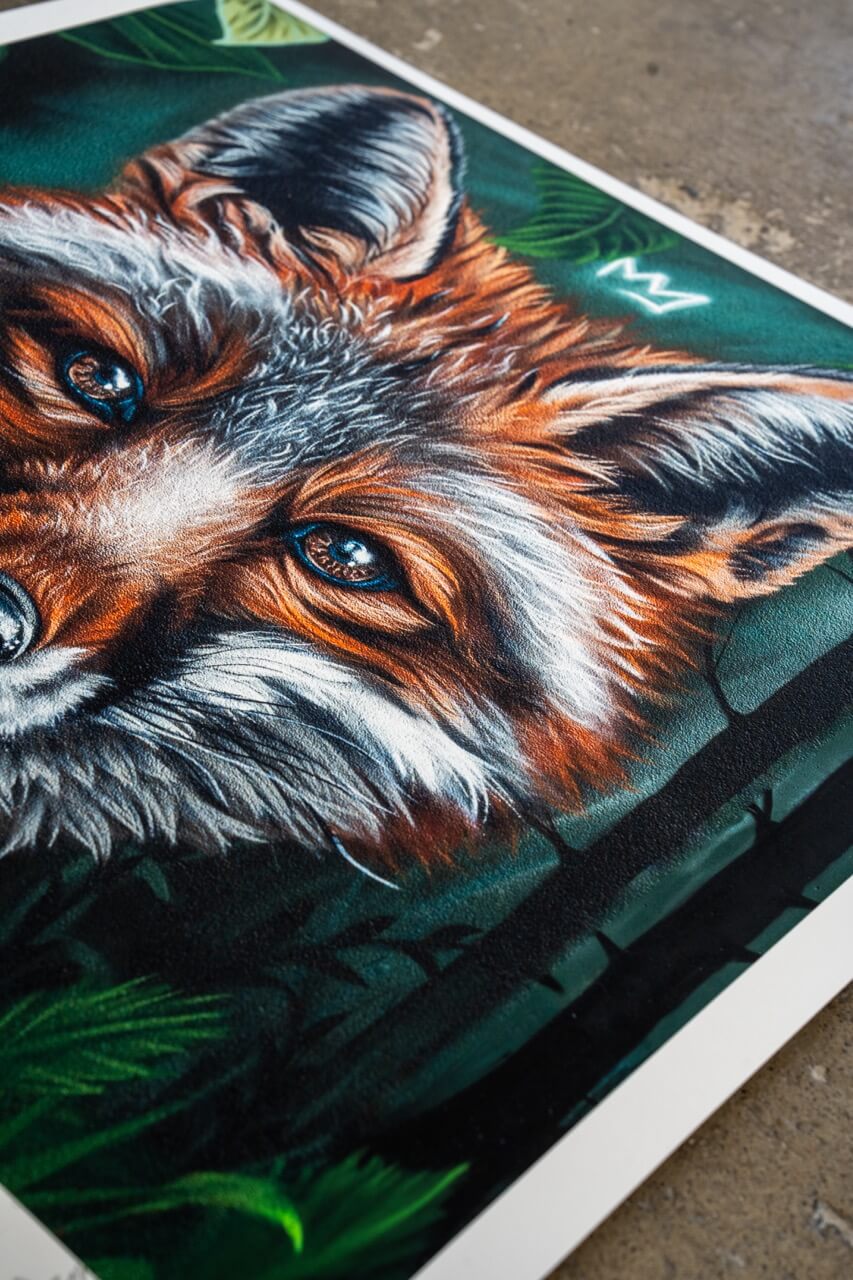 Detailaufnahme eines Kunstdrucks mit dem Porträt eines Fuchses. Das Fell ist in warmen Orange- und Brauntönen gehalten, mit feinen weißen und schwarzen Akzenten, die Struktur und Tiefe verleihen. Die leuchtenden blauen Augen ziehen den Blick auf sich und schaffen einen starken Kontrast zum dunklen, grünen Hintergrund mit angedeuteten Blättern und Ästen. Eine kleine Krone über dem Kopf des Fuchses verleiht dem Motiv eine besondere Symbolik. Der Druck zeigt eine sichtbare Textur, die die Detailtiefe verstärkt