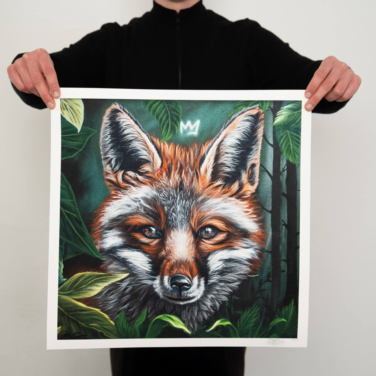 Ein hochwertiger Kunstdruck mit einer detailreichen Darstellung eines Fuchses, umgeben von dichtem, grünem Laub und dunklen Baumstämmen im Hintergrund. Der Fuchs blickt mit lebendigen, reflektierenden Augen direkt nach vorne, sein Fell ist in warmen Rot- und Brauntönen gehalten, mit weißen und schwarzen Akzenten für Textur und Tiefe. Über dem Kopf des Fuchses ist eine kleine, leuchtende Krone angedeutet.