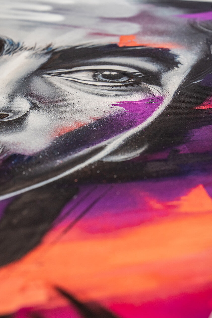 Nahaufnahme eines Street-Art-Gemäldes mit intensiven Farben und feinen Details. Der Fokus liegt auf dem ausdrucksstarken Auge, umgeben von dynamischen Pinselstrichen in Lila, Orange und Rot, die dem Porträt eine moderne und energiegeladene Ästhetik verleihen.