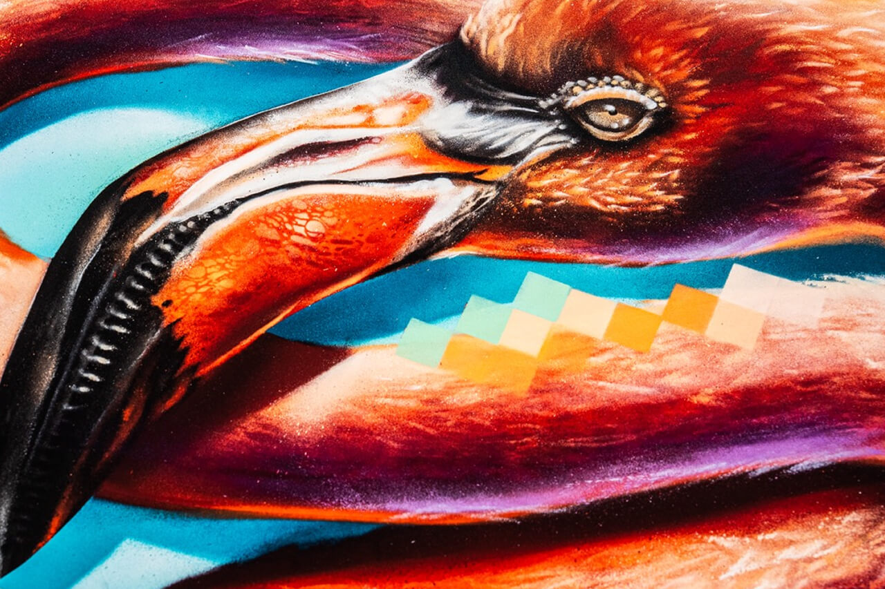 Nahaufnahme eines kunstvoll gestalteten Flamingo-Schnabels mit beeindruckender Detailtiefe. Die warmen Rottöne des Gefieders kontrastieren mit den kühlen Blautönen des Hintergrunds, während pixelartige Muster einen modernen, digitalen Akzent setzen.